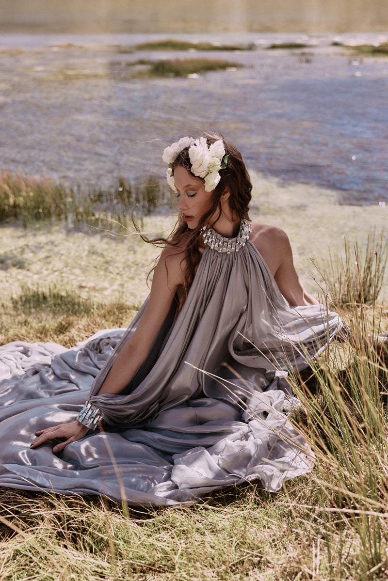 Silver chiffon lam dress with halter neck and sleeves, featuring baguette embroidery on neckline and cuffs Silver chiffon lam dress with halter neck and sleeves, featuring baguette embroidery on neckline and cuffs