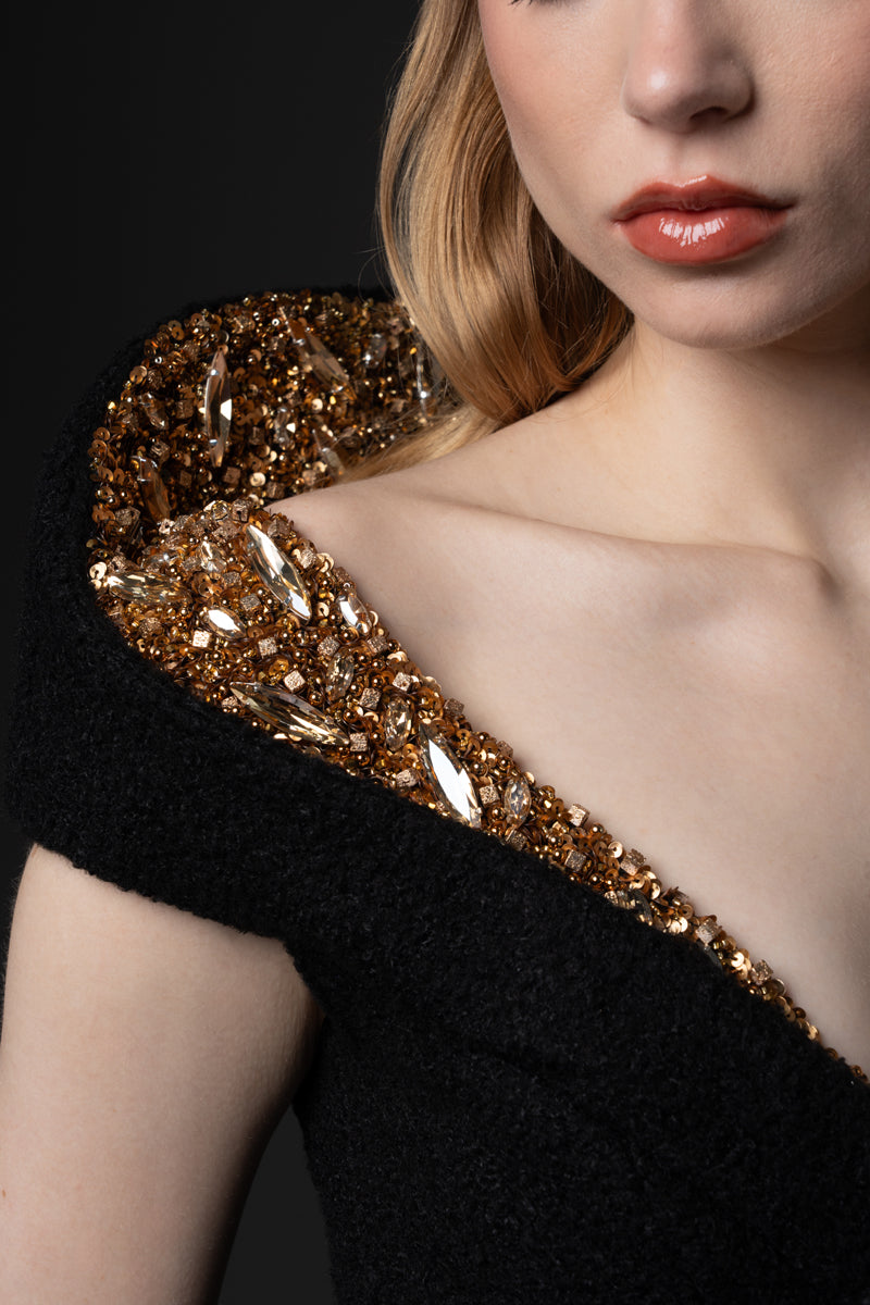 A bouclé gown with a V neckline and a structured beaded collar