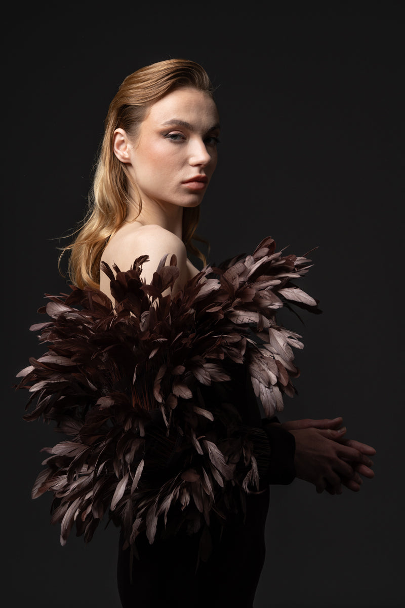 A crêpe gown with voluminous feathers on neckline and sleeves