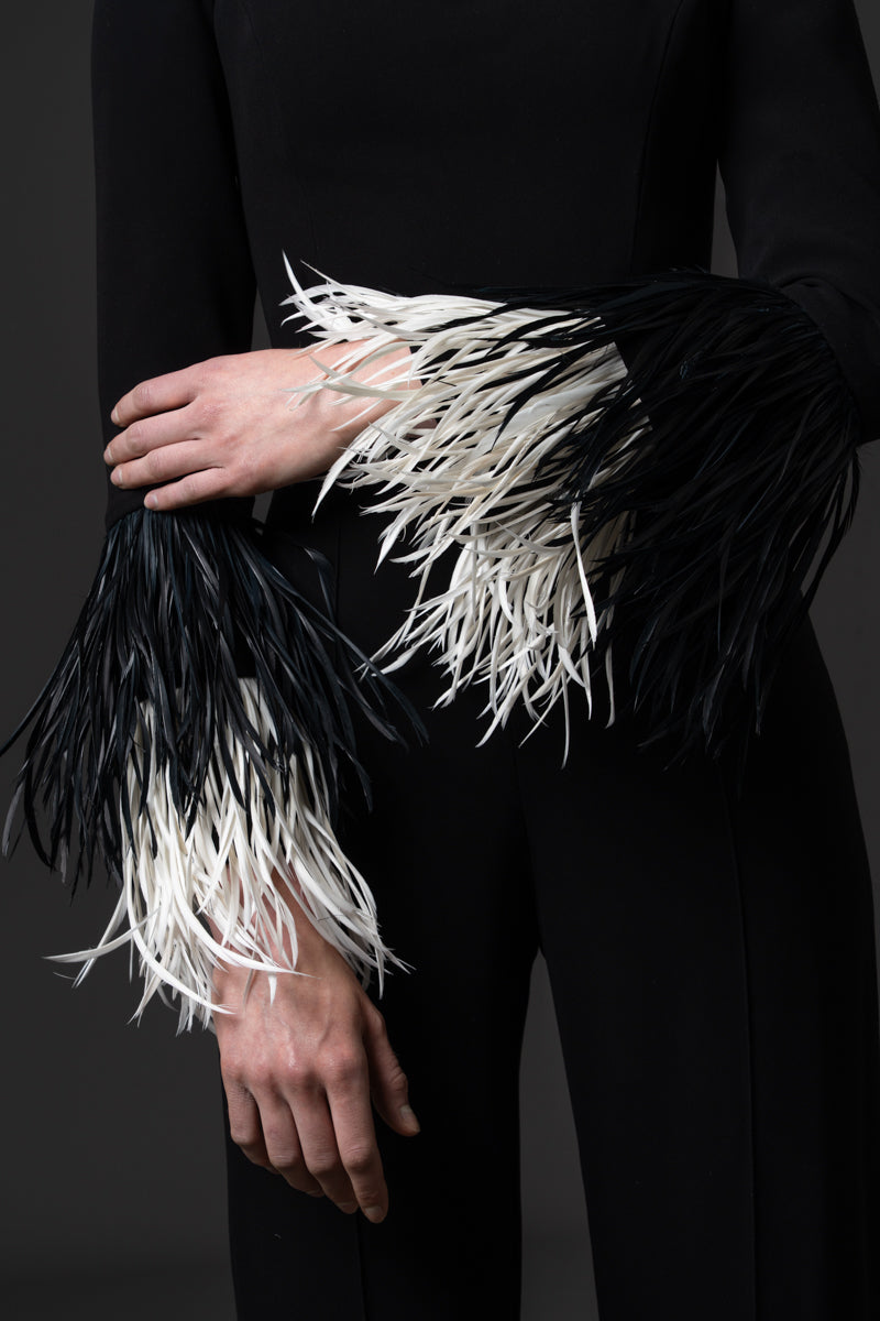 A crêpe jumpsuit with a square neckline and feathered cuff details