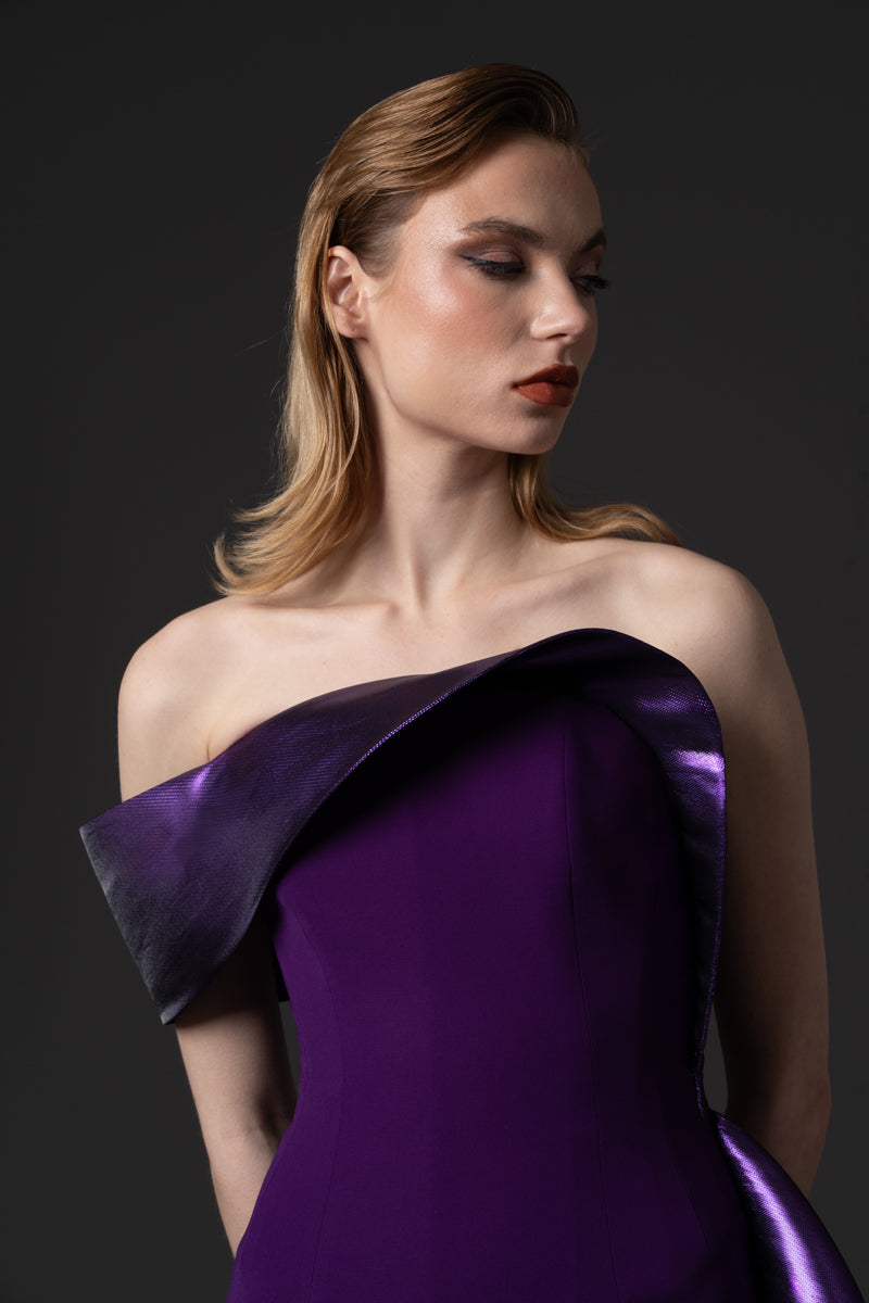 A fitted crêpe gown with a sculptural neckline layered with a voluminous asymmetrical lamé overskirt