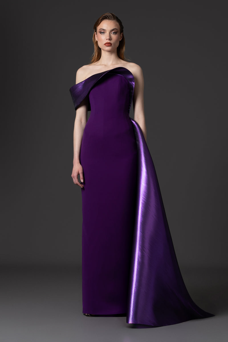 A fitted crêpe gown with a sculptural neckline layered with a voluminous asymmetrical lamé overskirt