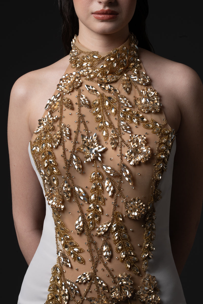 A fitted halter neck crêpe gown embellished with stones in the middle