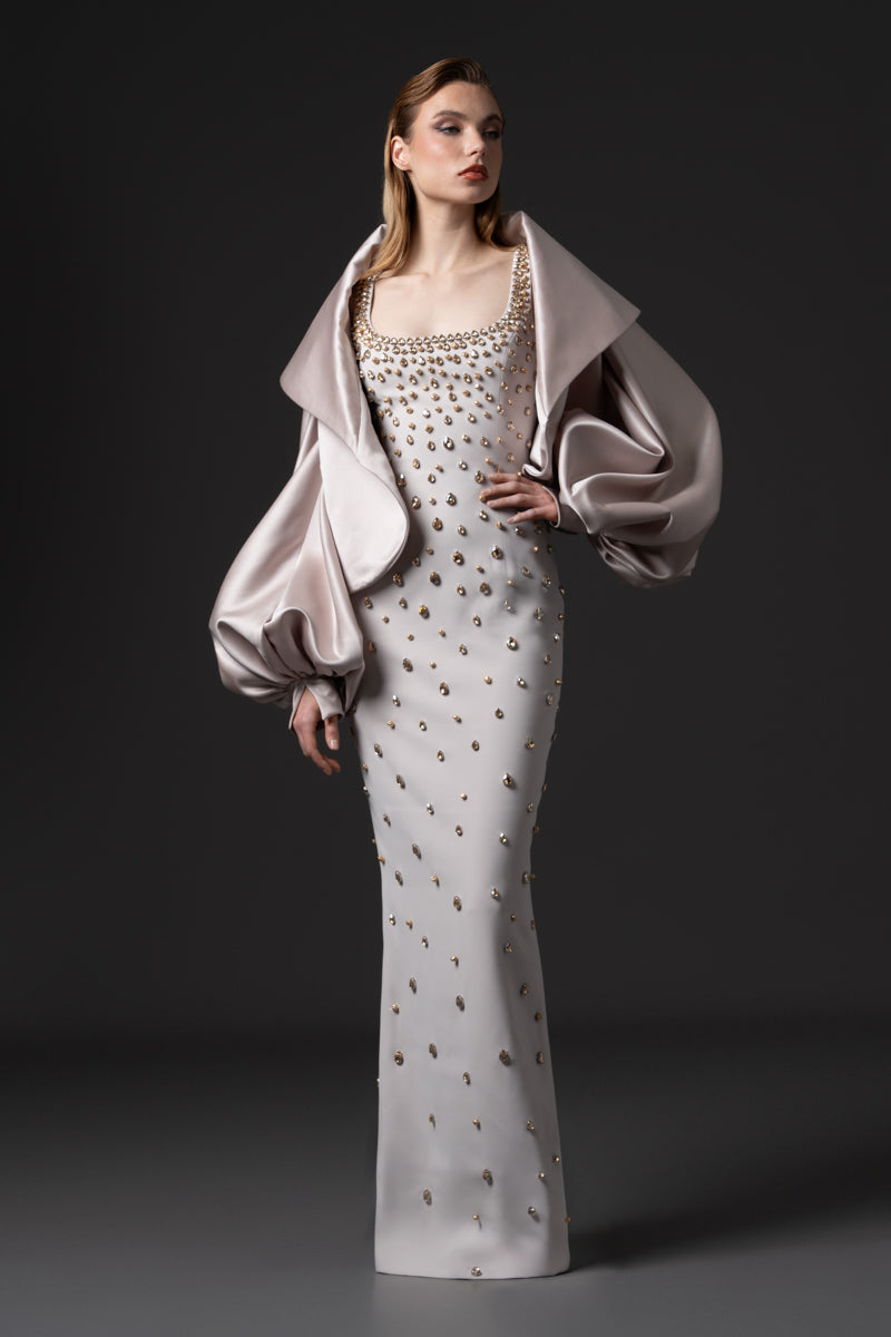 A fitted round neckline crêpe gown beaded with navette stones with a radzimir bomber jacket