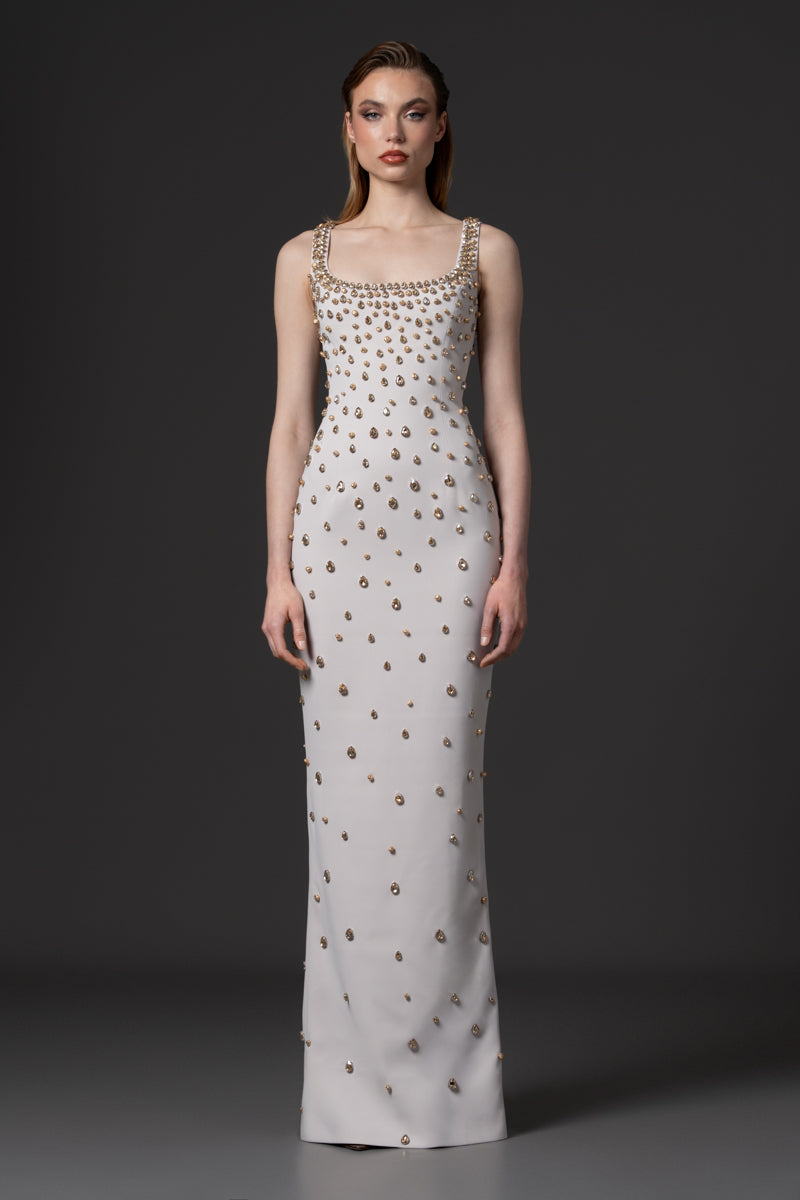 A fitted round neckline crêpe gown beaded with navette stones with a radzimir bomber jacket