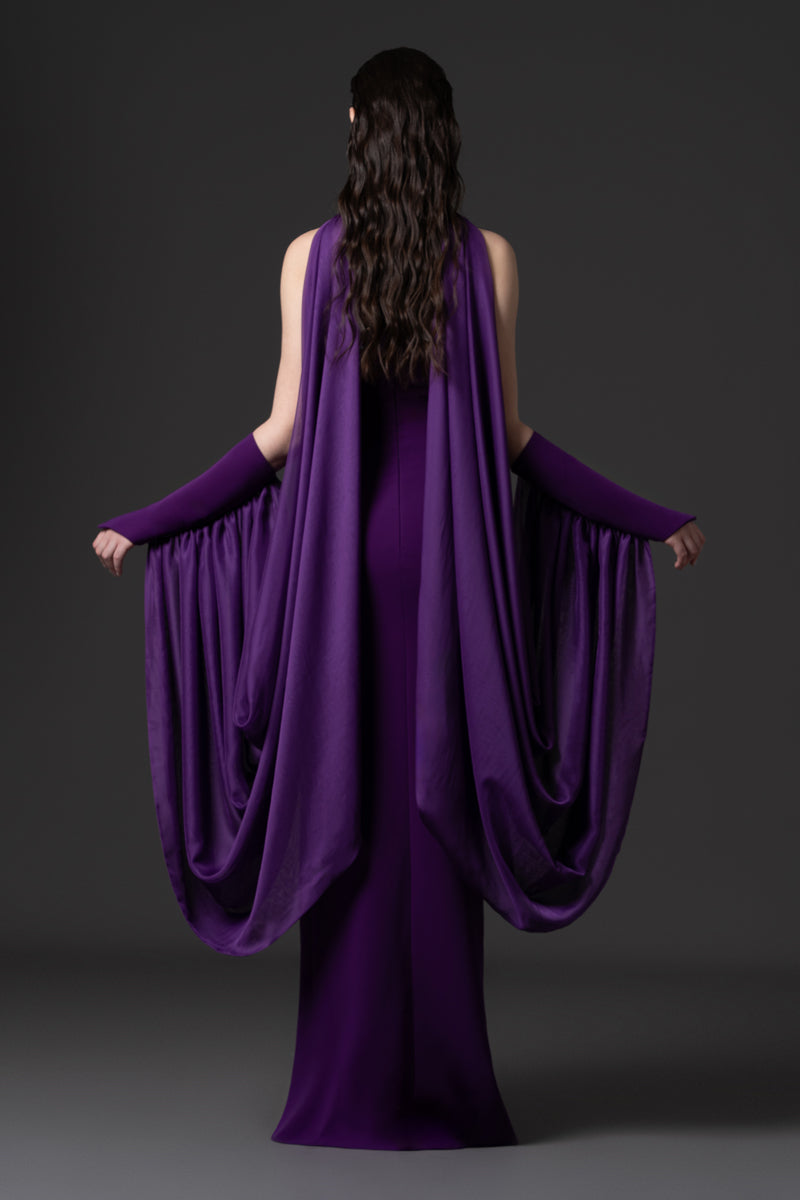 A halter-neck crêpe gown with beaded borders and draped chiffon connected
to the sleeves
