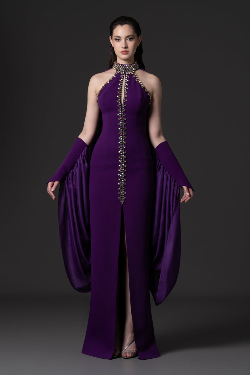 A halter-neck crêpe gown with beaded borders and draped chiffon connected
to the sleeves