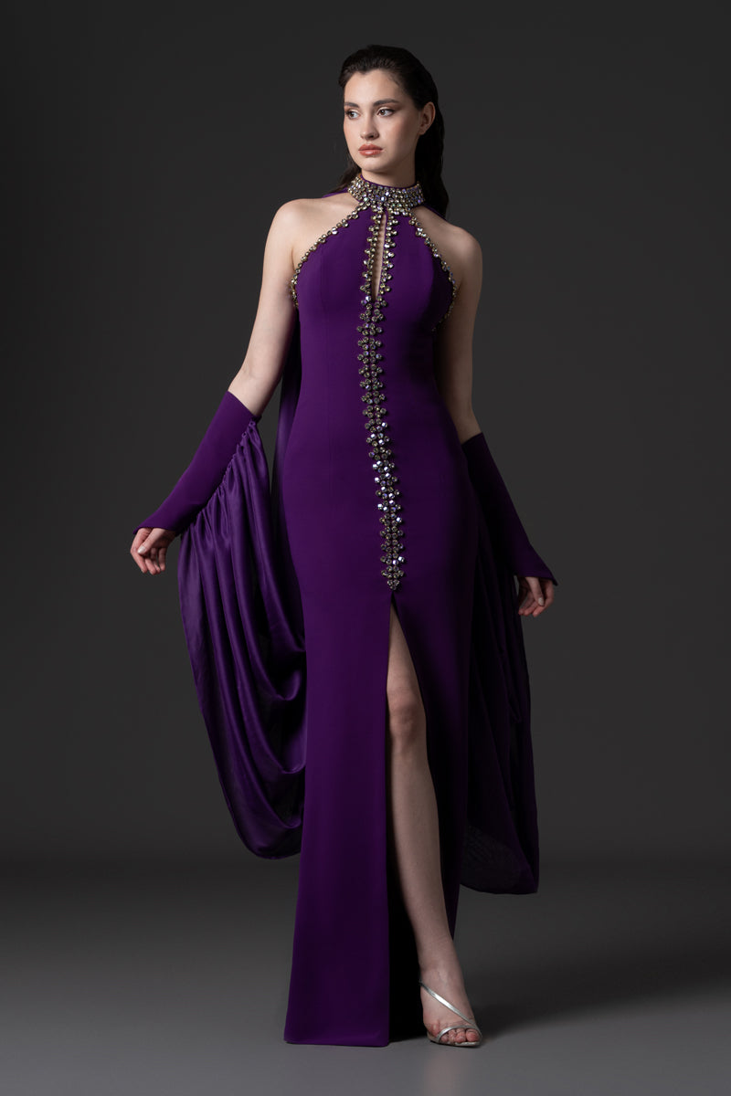 A halter-neck crêpe gown with beaded borders and draped chiffon connected
to the sleeves