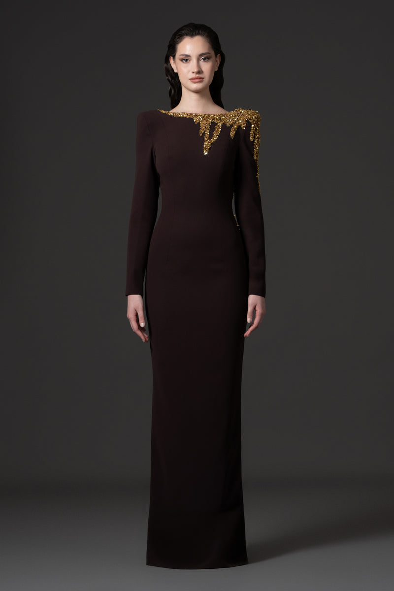 A long sleeves fitted crêpe gown with an open back and beaded with sequins