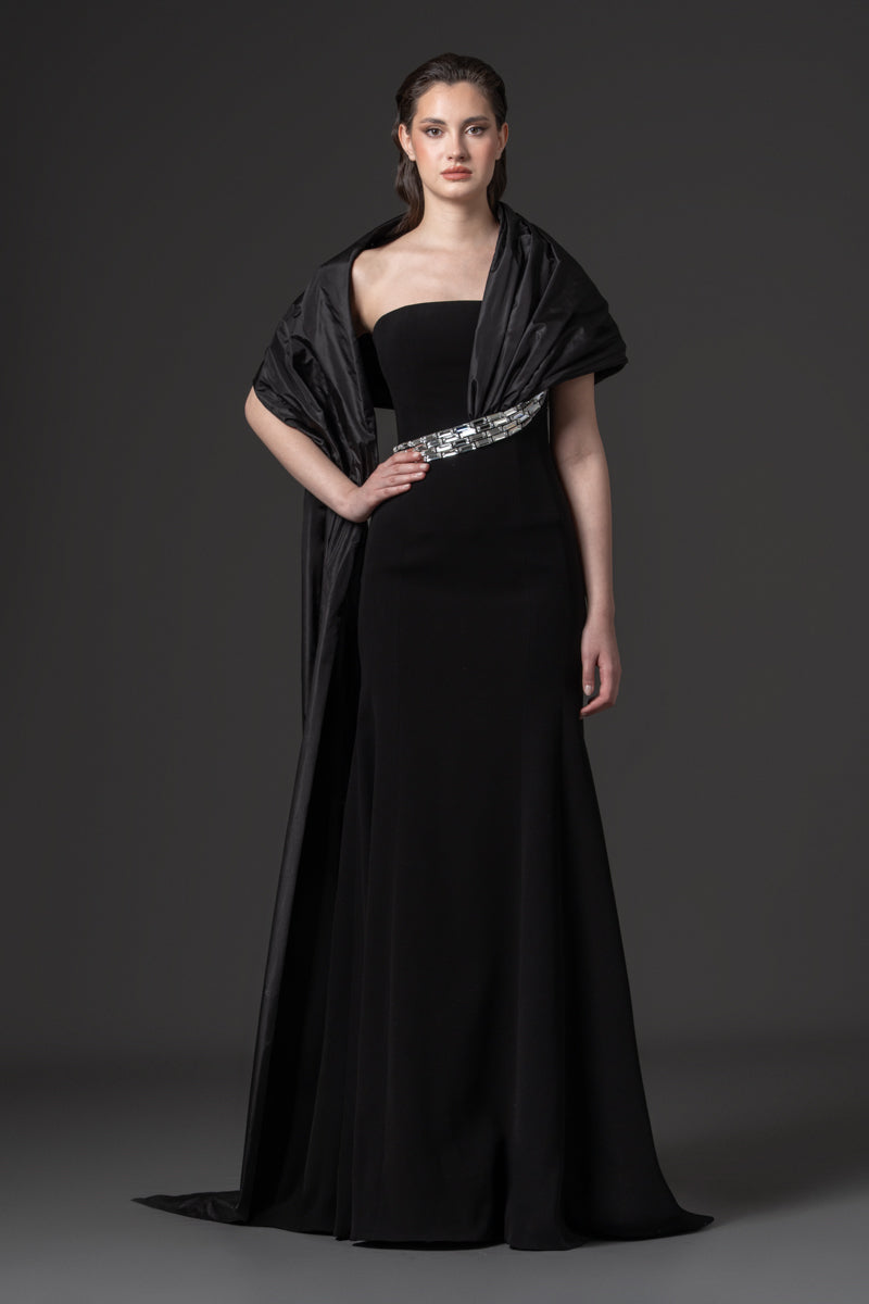 A strapless crepe gown with an elegant off-the-shoulder taffeta drape and baguette stones at the waist