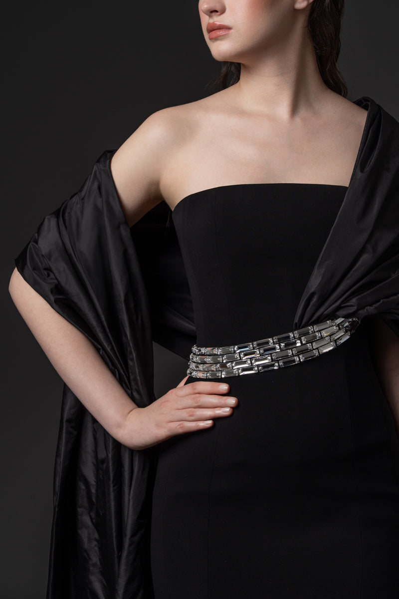 A strapless crepe gown with an elegant off-the-shoulder taffeta drape and baguette stones at the waist
