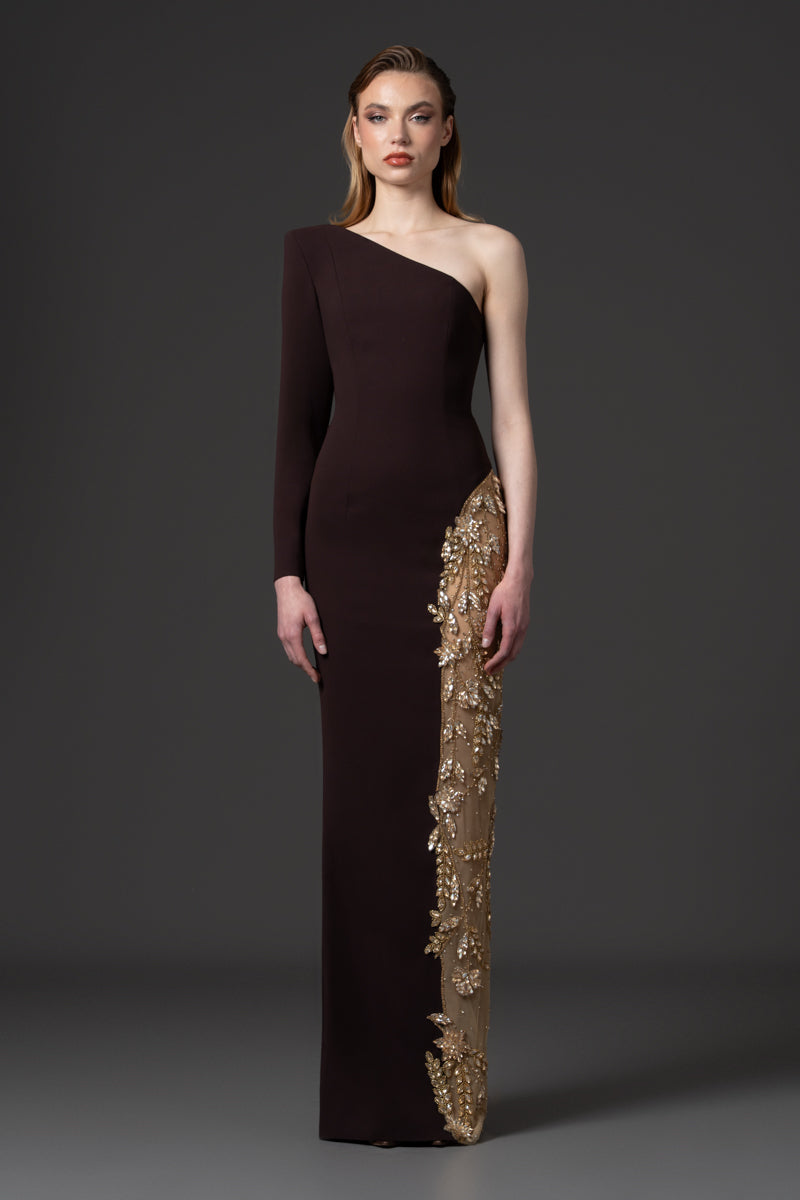 An asymmetrical gown designed with a high slit beaded with crystals