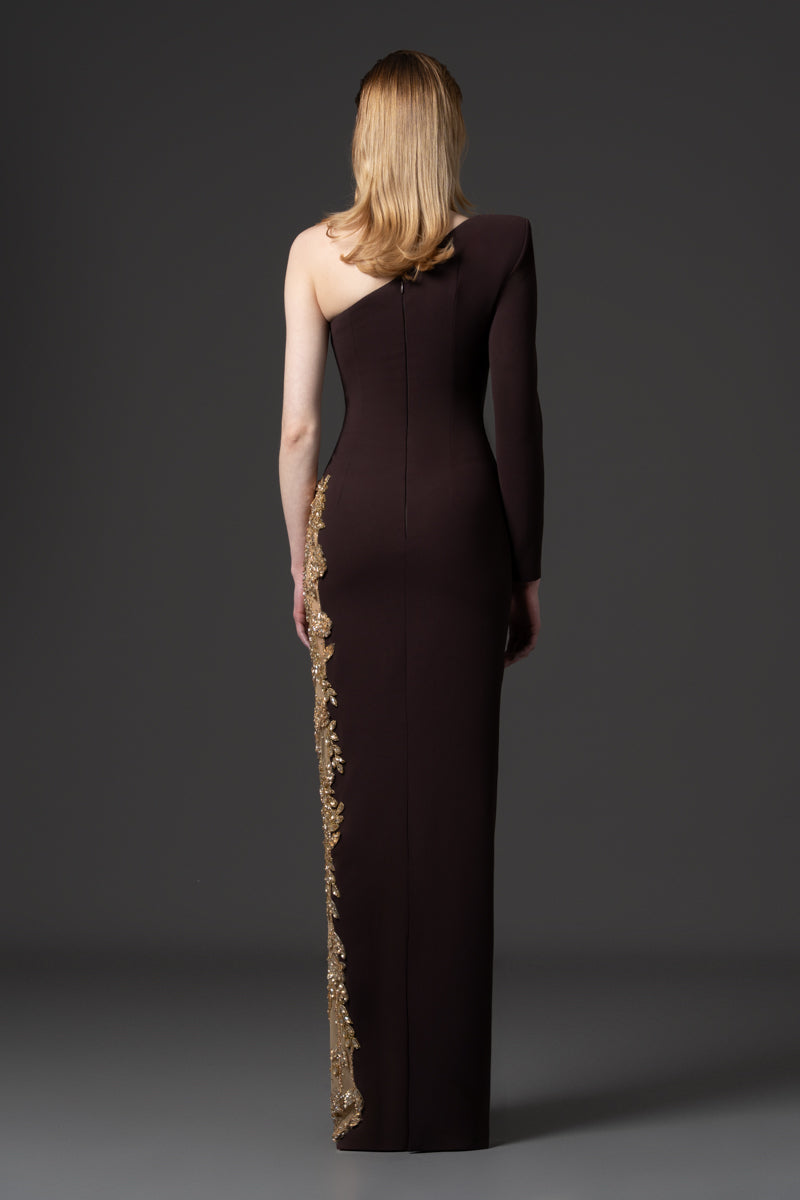 An asymmetrical gown designed with a high slit beaded with crystals