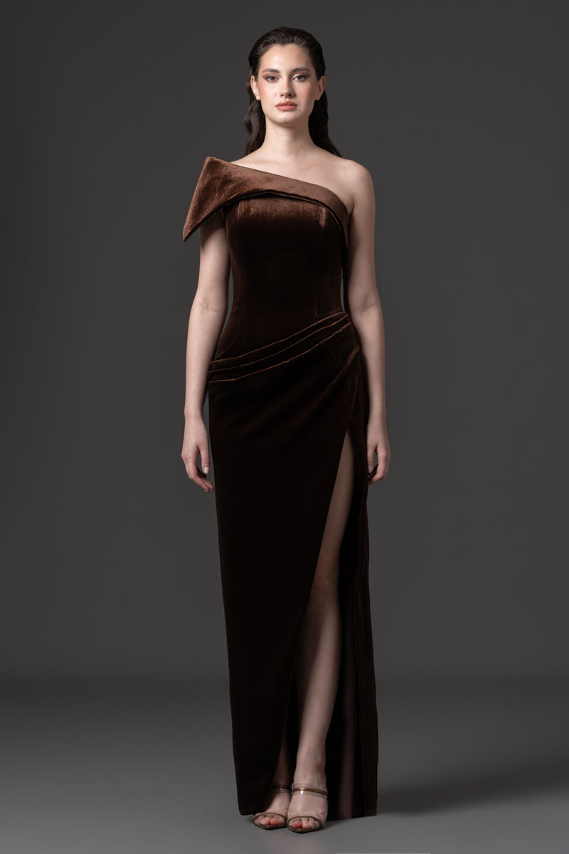 An asymmetrical velvet dress with draping on the waist and a high slit