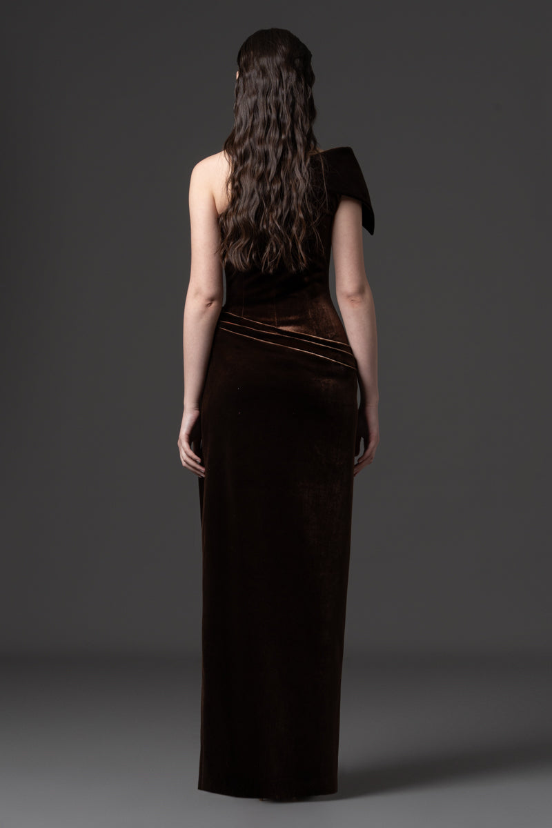 An asymmetrical velvet dress with draping on the waist and a high slit