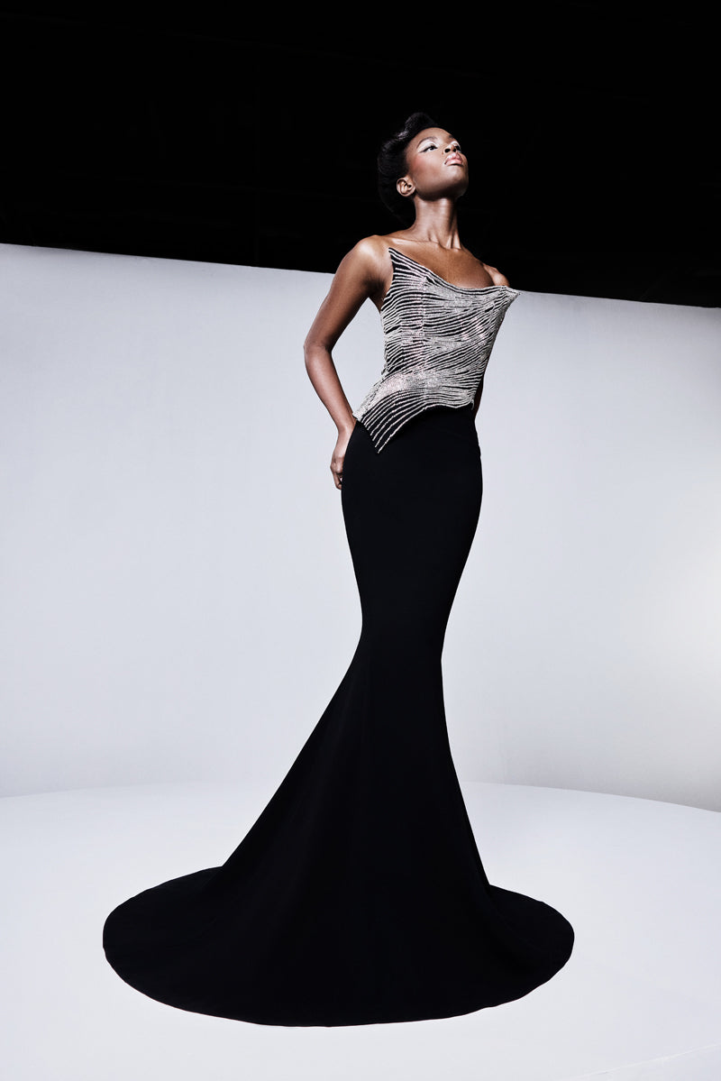 A fitted mermaid crêpe gown designed with a beaded pointed corset