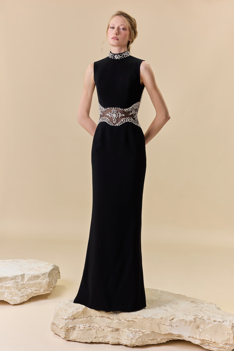 A crêpe fitted dress with an open back, a train at the back, and crystal detailing along the neckline, waist, and back borders.