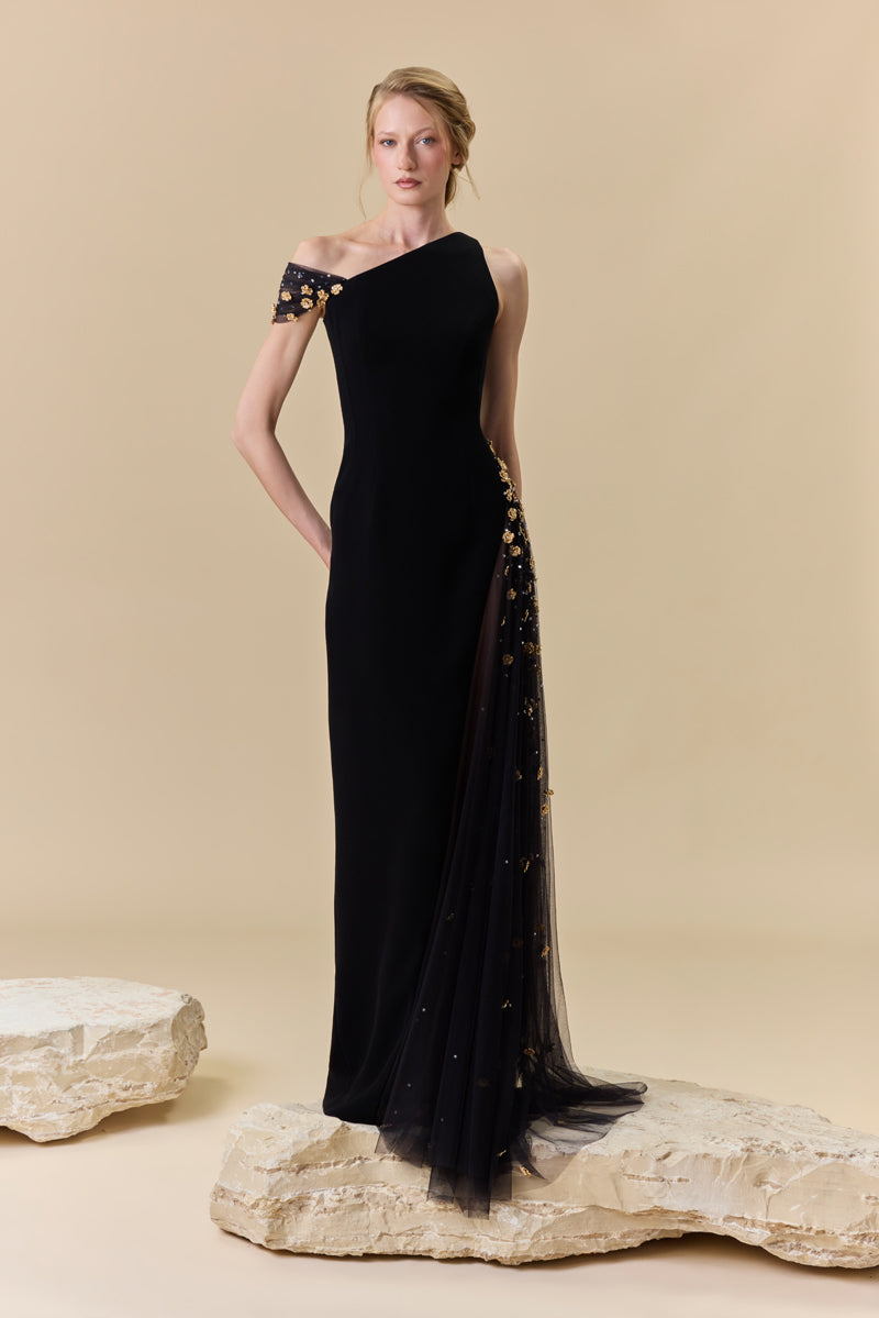 A crêpe one-shoulder fitted gown with a tulle side panel with metallic flowers and crystal beadings along the waist.