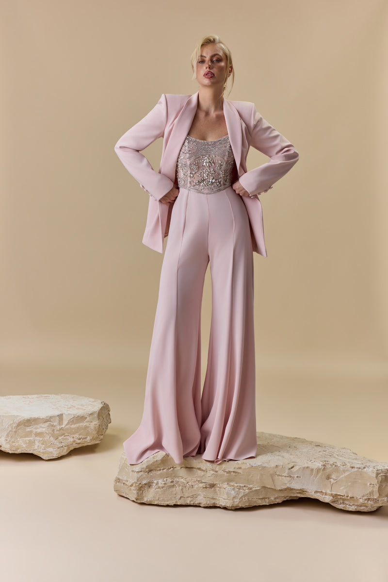 A strapless crêpe jumpsuit with an embroidered tulle corset embellished with crystals and stones, paired with a matching crêpe jacket.