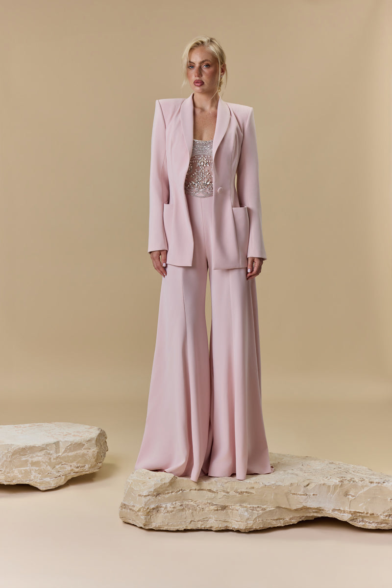 A strapless crêpe jumpsuit with an embroidered tulle corset embellished with crystals and stones, paired with a matching crêpe jacket.