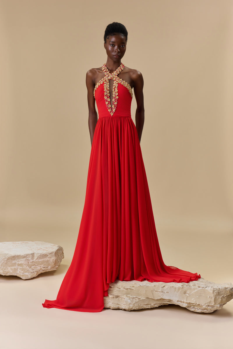 A georgette halter-neck dress embellished with metallic flowers and crystals neckline, waist draping, an open back, and a flowing A-line skirt.