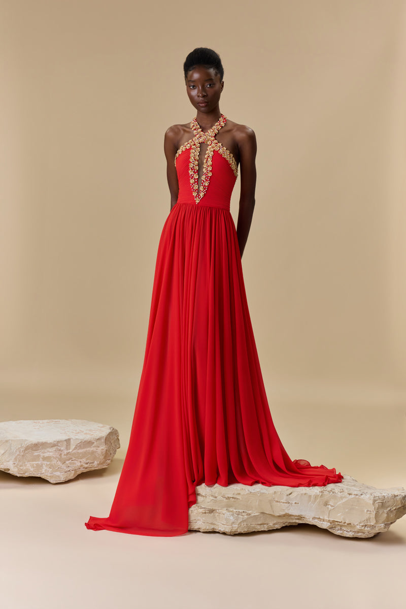 A georgette halter-neck dress embellished with metallic flowers and crystals neckline, waist draping, an open back, and a flowing A-line skirt.