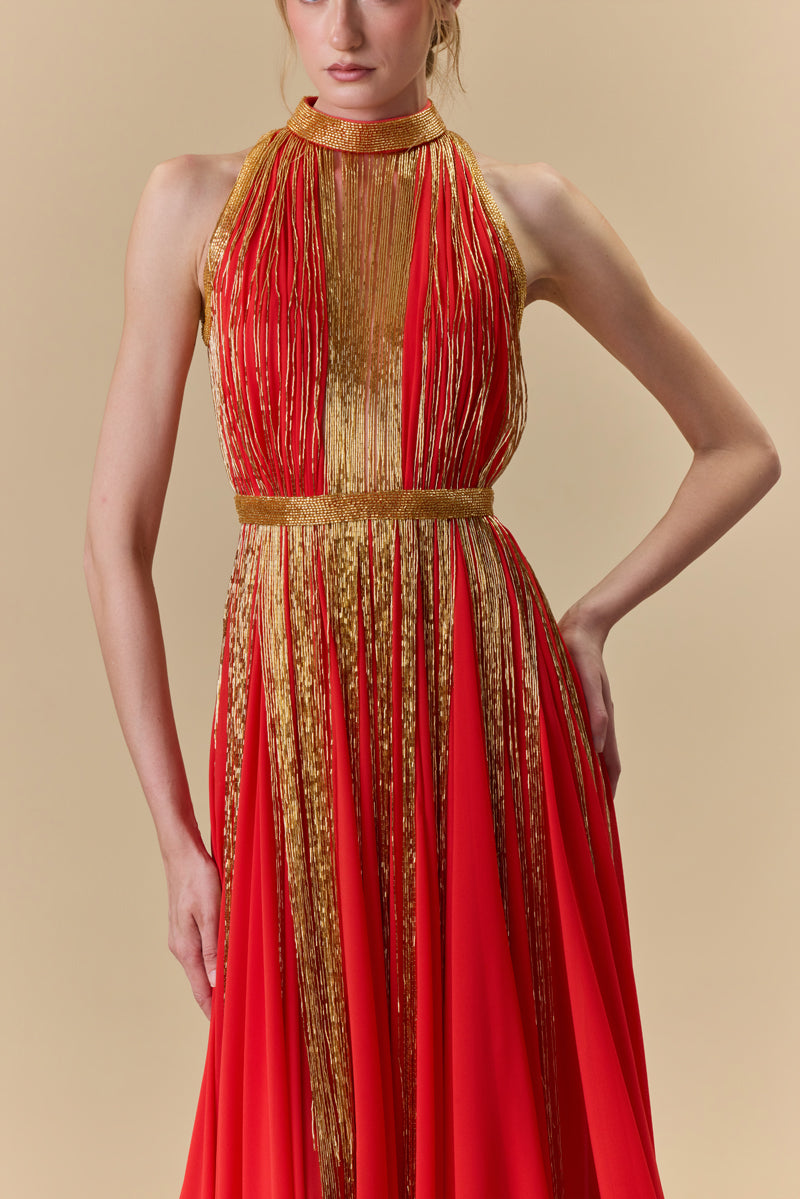 A halter neck dress featuring a crepe bodice and an A-line chiffon skirt with beaded fringes on it.