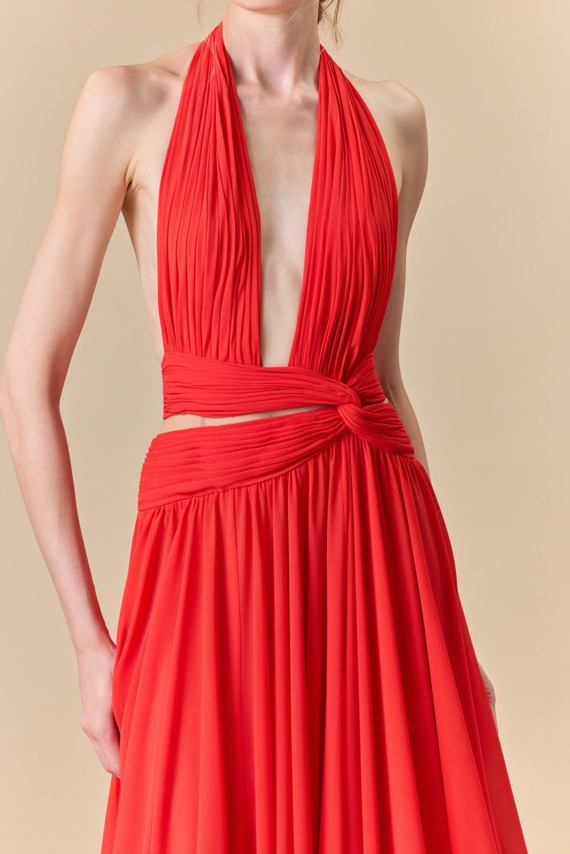 A flowing deep V georgette dress with a knot detail at the waist and a high slit.
