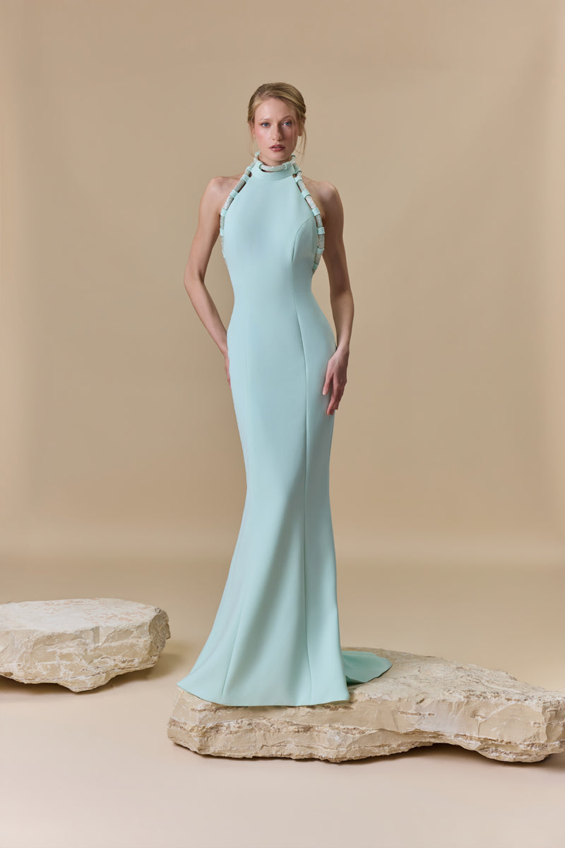 A fitted crepe halter-neck dress featuring beaded cords along the neckline and an open back.