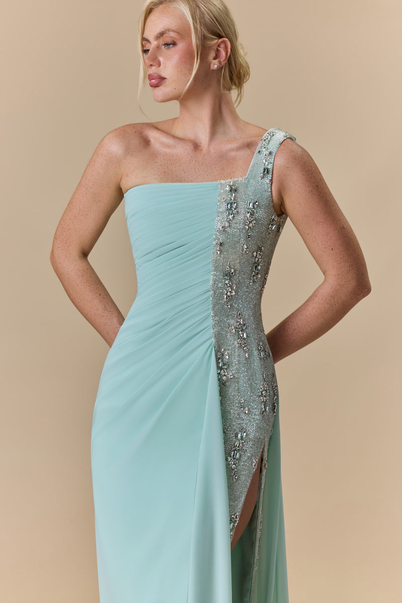 An asymmetrical one shoulder georgette dress featuring horizontal draping across the bodice and a crystal-embellished side panel.