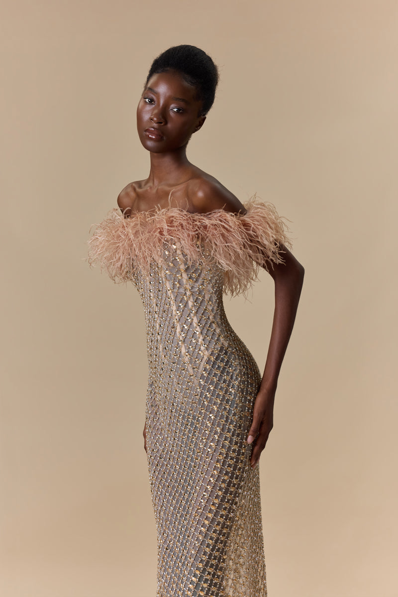A strapless fitted dress fully beaded with crystals and finished with an off-shoulder feather trimmed neckline.