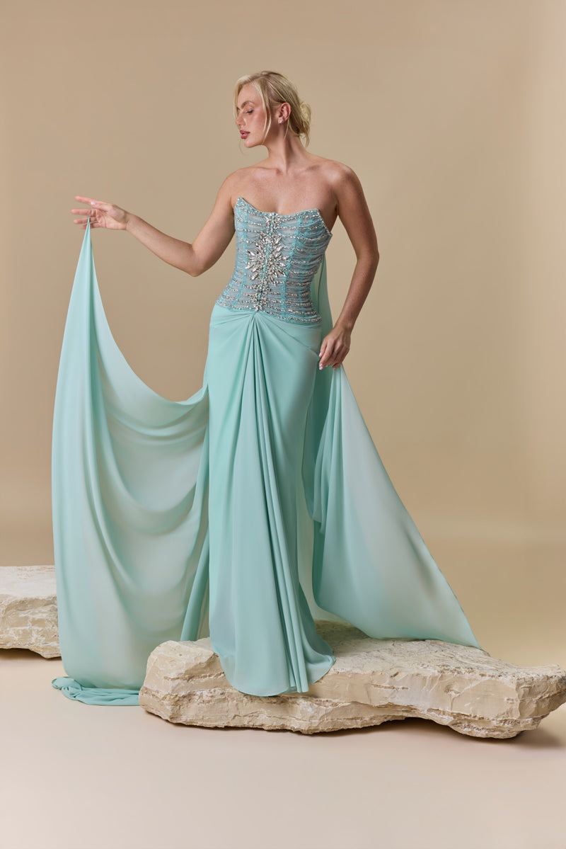 A strapless dress featuring a crystal-embellished corset bodice and a draped georgette skirt with a flowing back train.