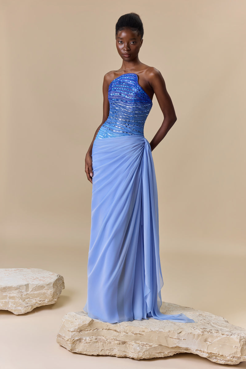 A strapless dress featuring an asymmetrical bodice with degraded crystal embroidery and a draped chiffon skirt.
