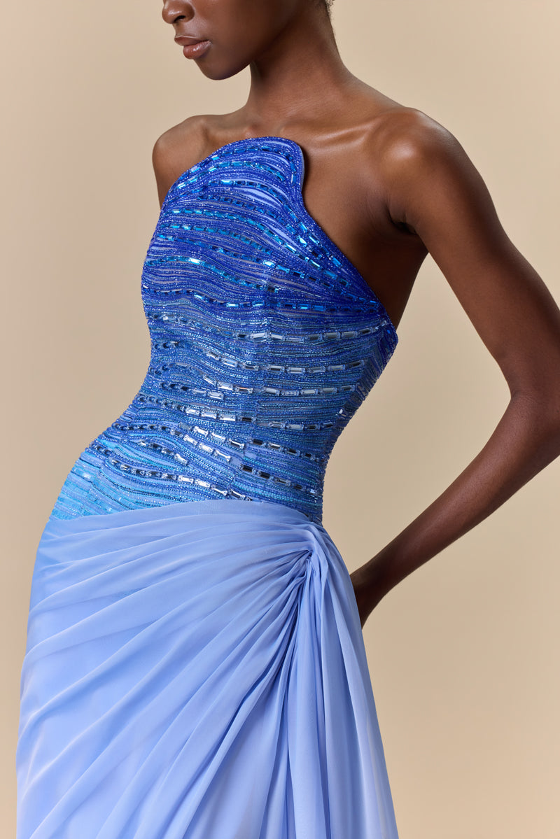 A strapless dress featuring an asymmetrical bodice with degraded crystal embroidery and a draped chiffon skirt.