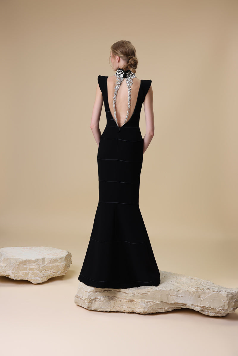 A crêpe fitted dress with a deep V neckline and horizontal radzimir detailing along the silhouette.