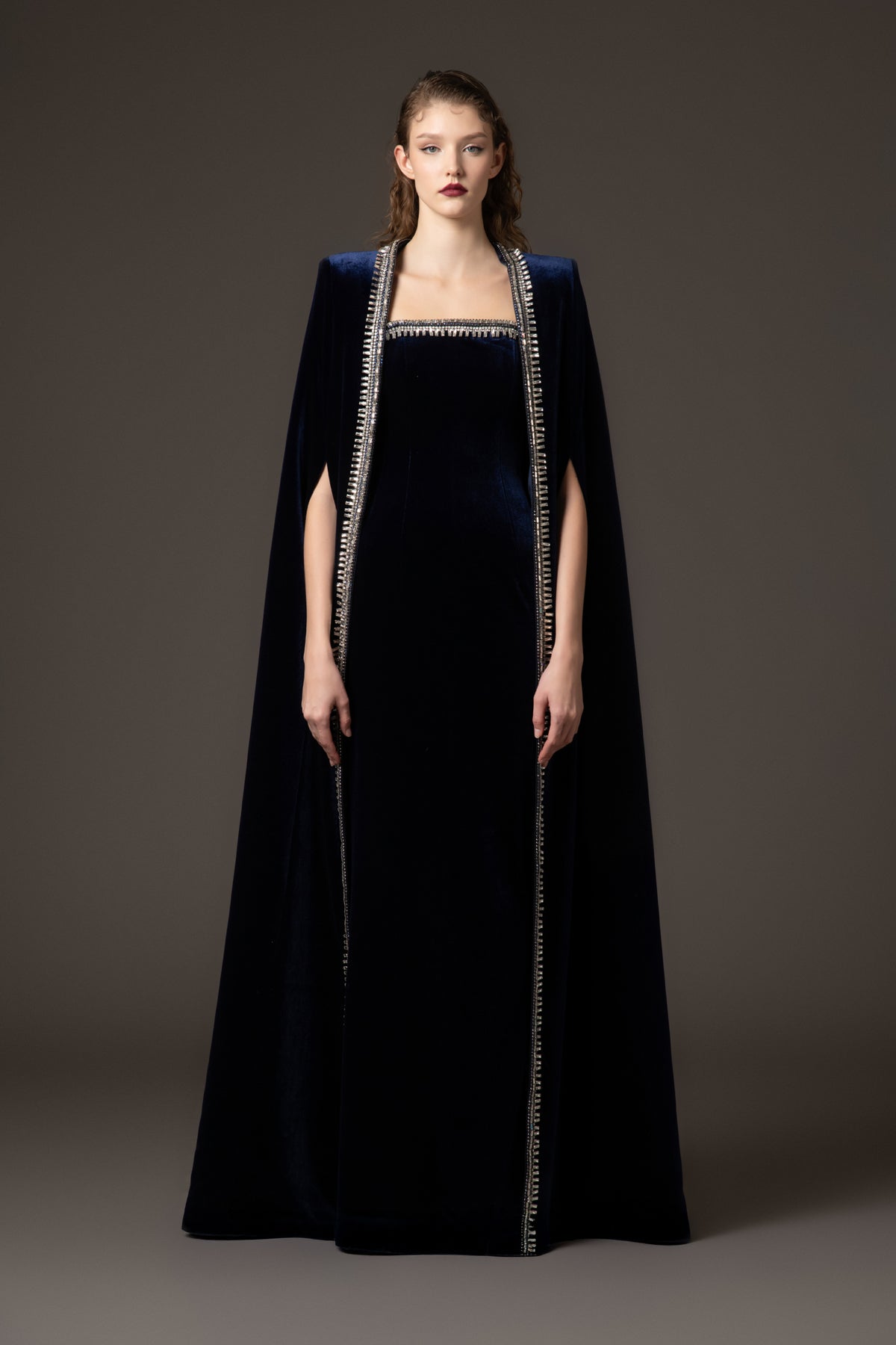 Embroidered velvet blue dress paired with a cape