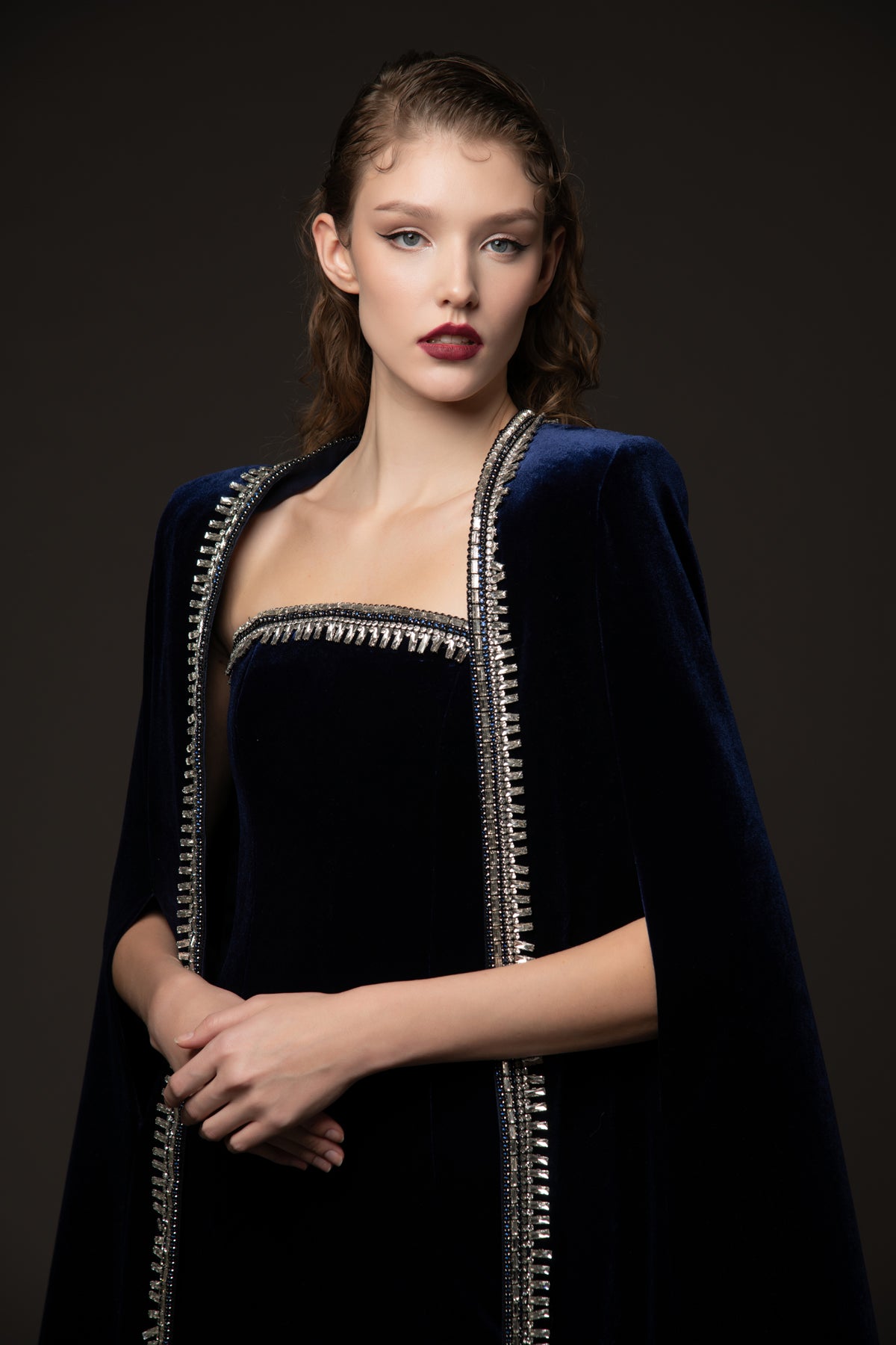 Embroidered velvet blue dress paired with a cape