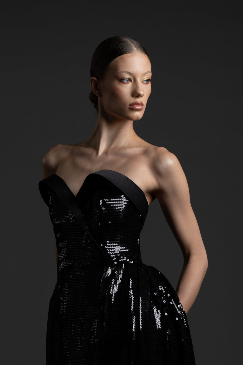 Strapless black sequin dress , featuring a one sided overskirt and a satin bustline
