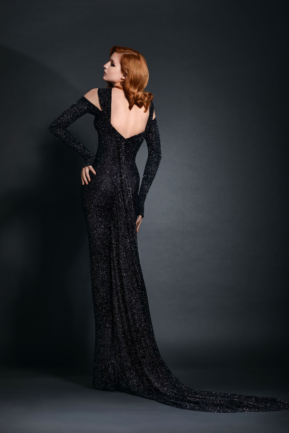 Plunging black star-dust silhouette hugging dress with center front gunmetal harness ring and a cascading floor length train