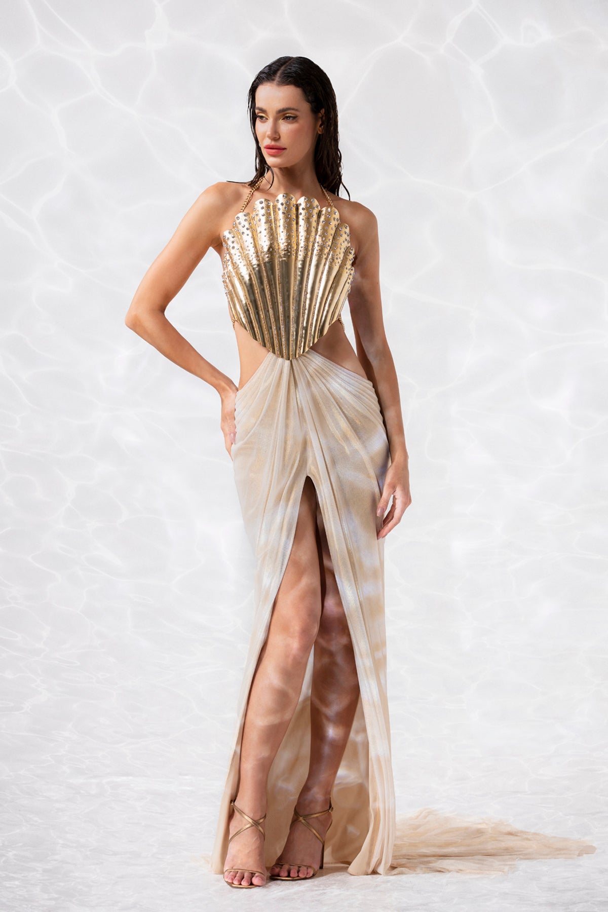 Sleeveless gold-plated scallop shell corset handcrafted from solid brass and studded with crystals, worn with a draped skirt in gold foiled silk tulle