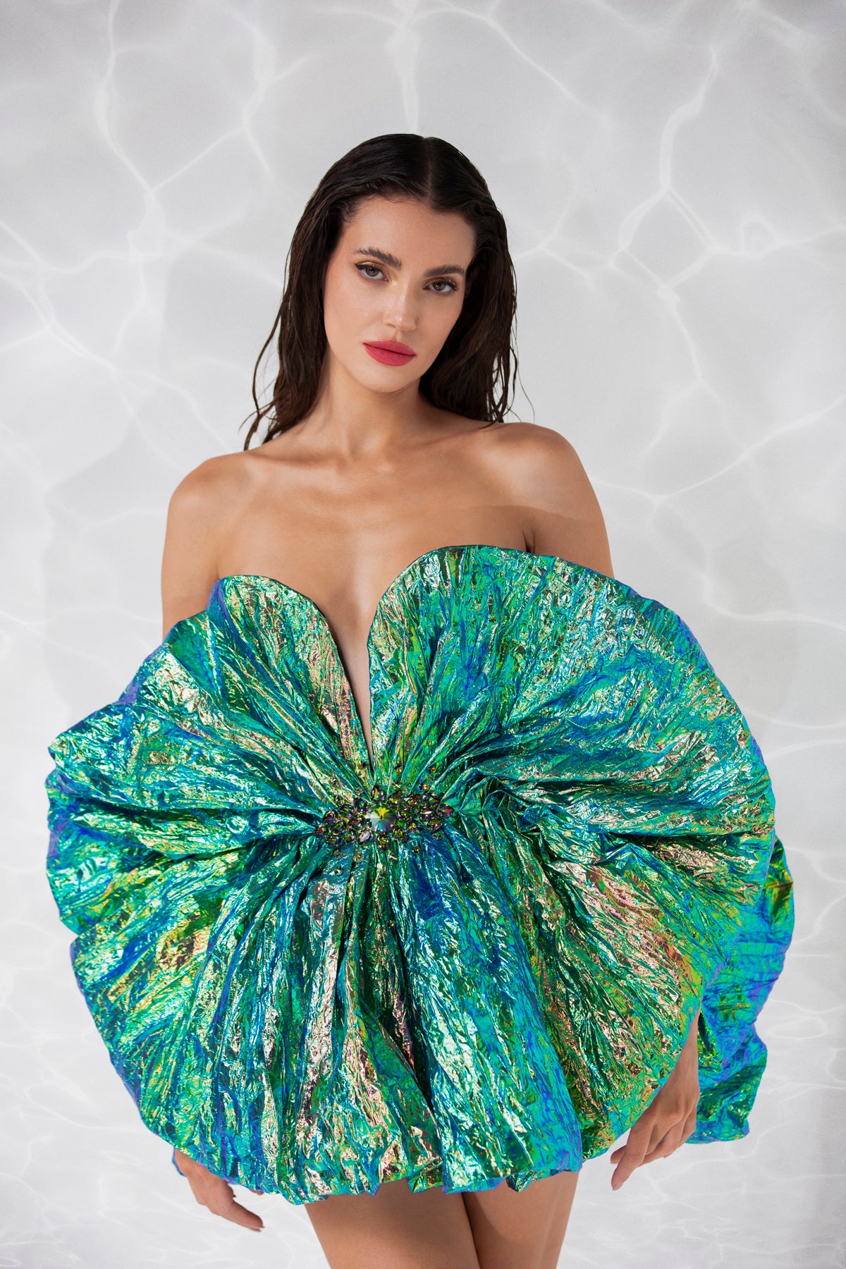 Plunging corseted mini dress in iridescent foiled pleats and a crystal embellished brooch