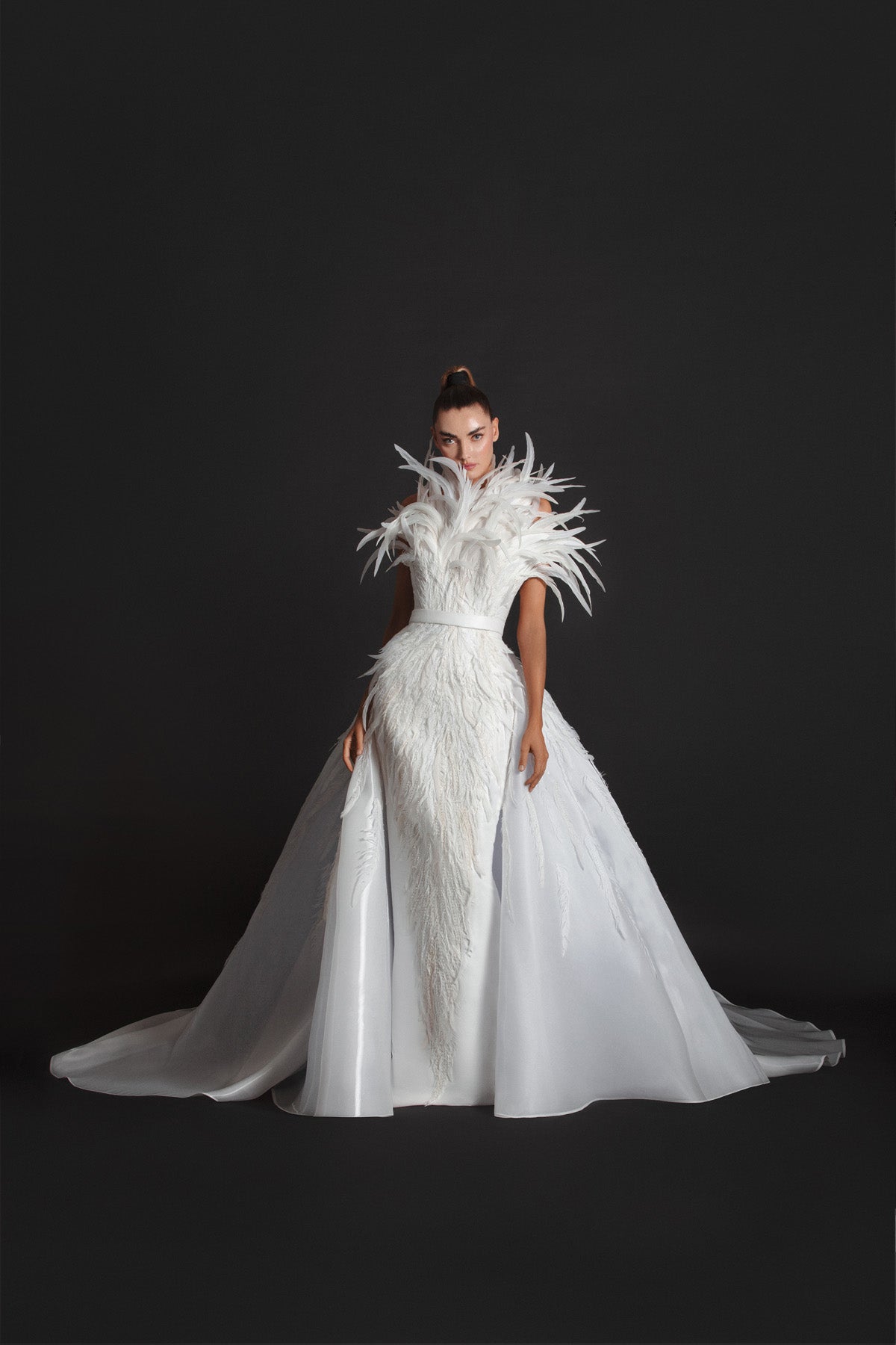 Strapless off-white liquid gazaar gown with voluminous floor sweeping overskirt; hand appliquéd with coq plumes and embroidered with Swarovski crystals