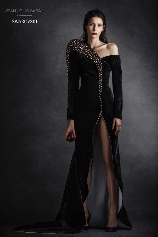 Asymmetrical black velvet mermaid gown with oversized structured shoulder, embellished with Swarovski crystals