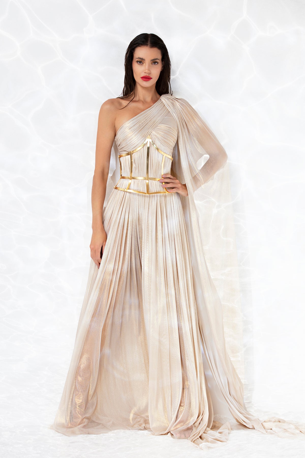Exquisitely draped asymmetric gown in gold foiled silk tulle, worn with a gold-plated corset handcrafted from solid brass