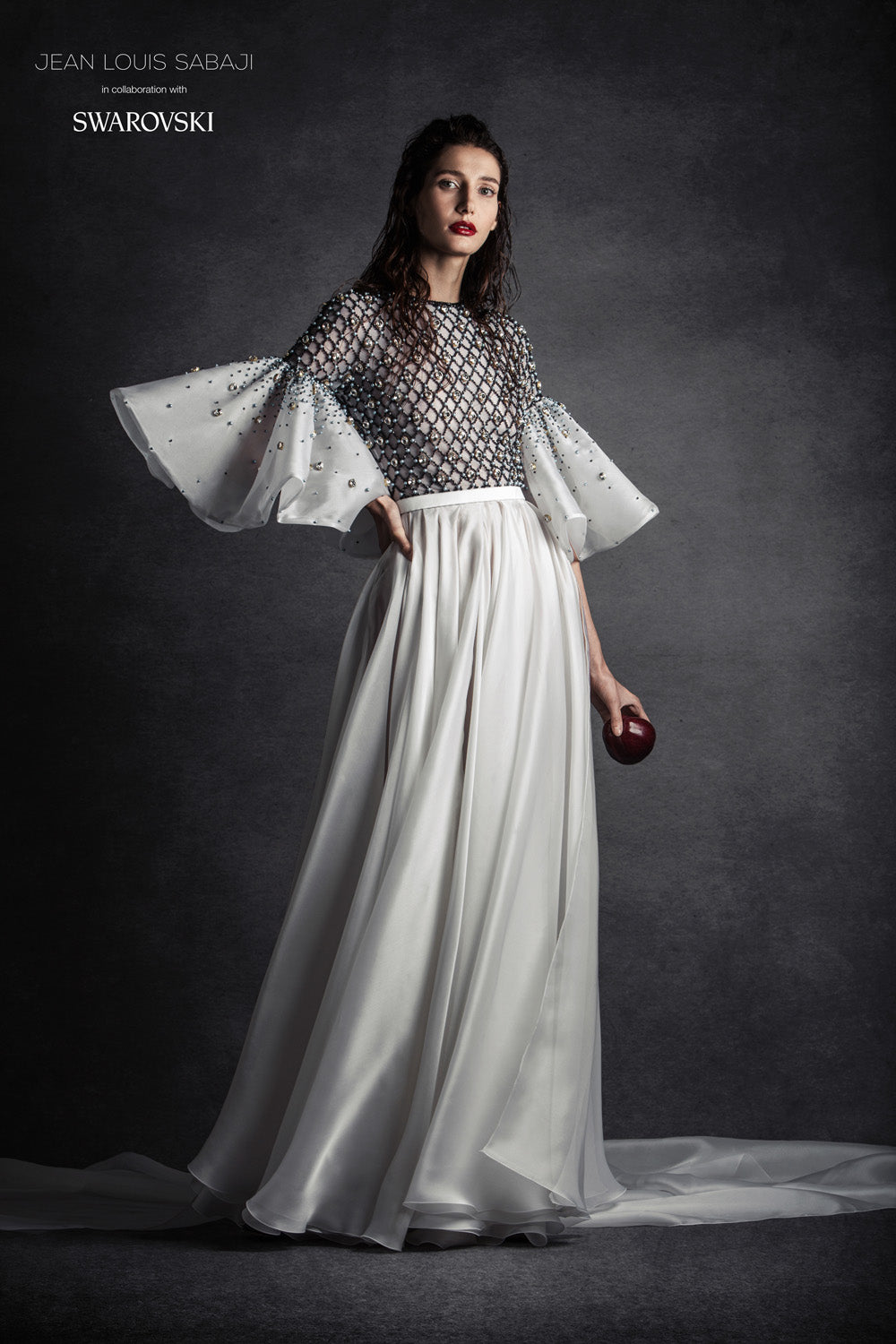 Hand-painted white silk crêpe A-line gown with criss cross detailing embellished with Swarovski crystals and pearls