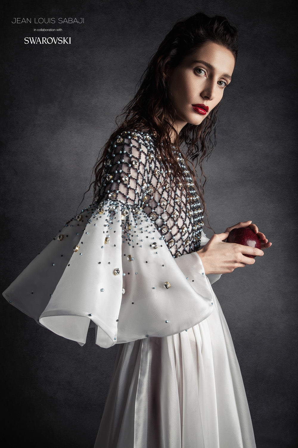 Structured hand-painted white silk crêpe A-line gown with criss cross detailing embellished with Swarovski crystals and pearls