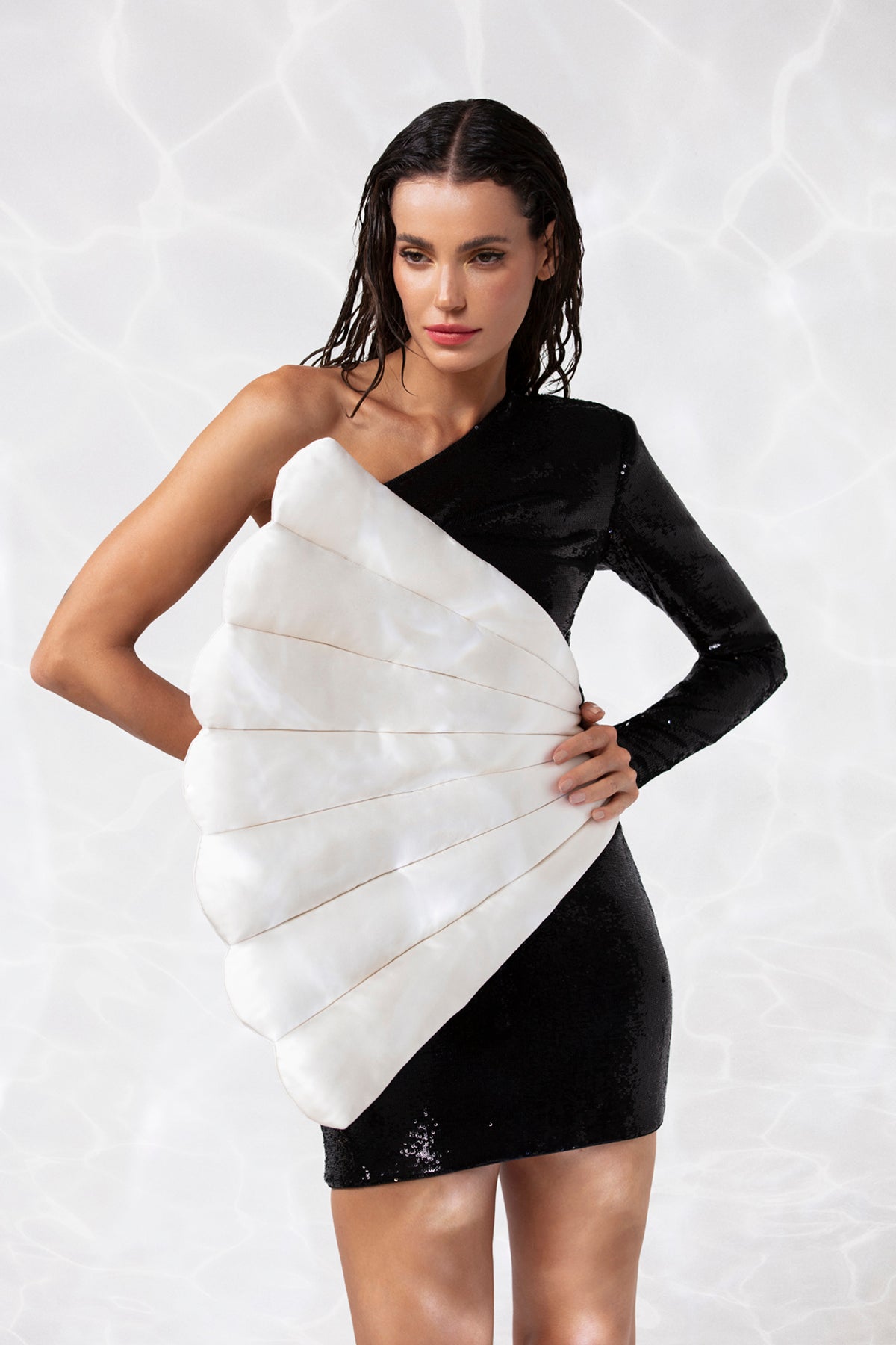 One sleeve mini dress in jet black sequins featuring a scallop shell handcrafted in padded silk satin