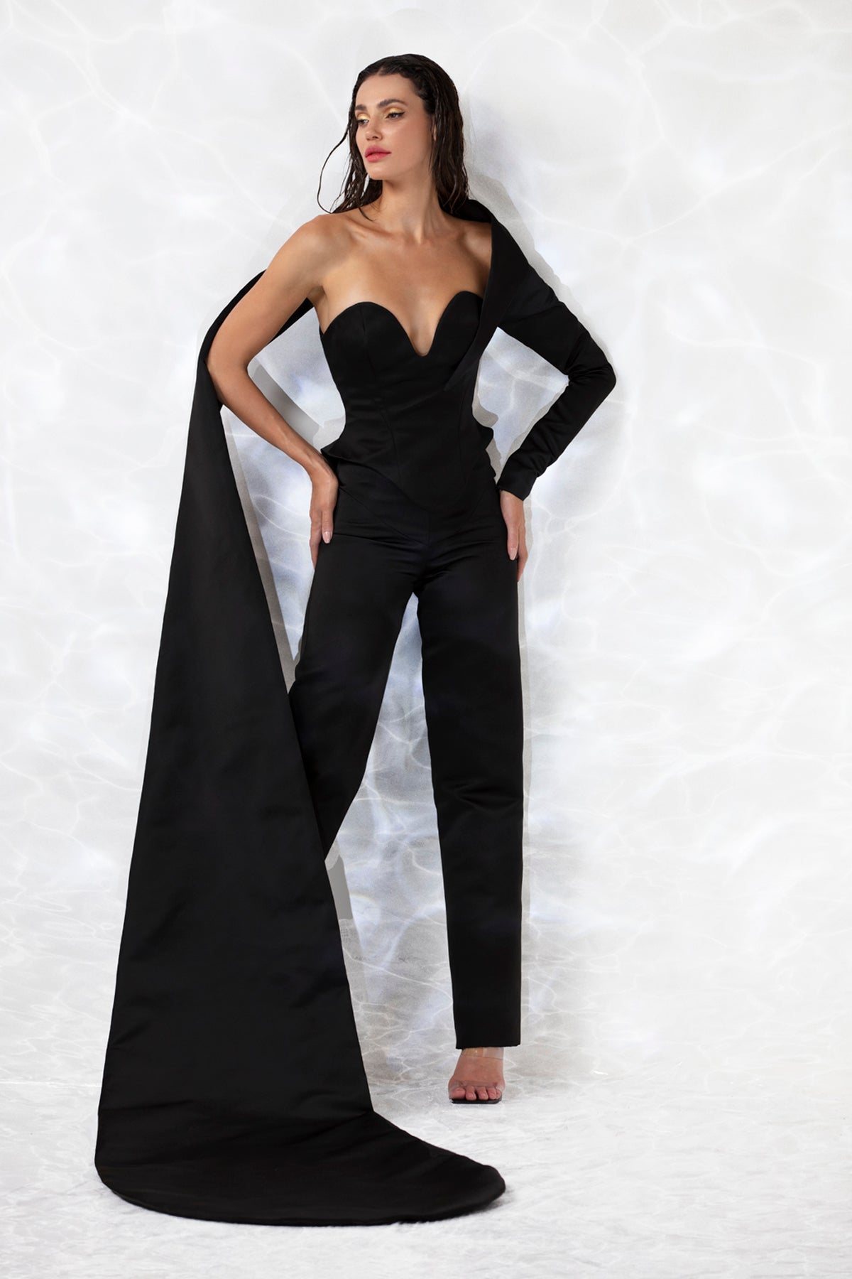 Black scuba ensemble consisting of a corseted bustier top with a floor sweeping train and straight leg trousers.