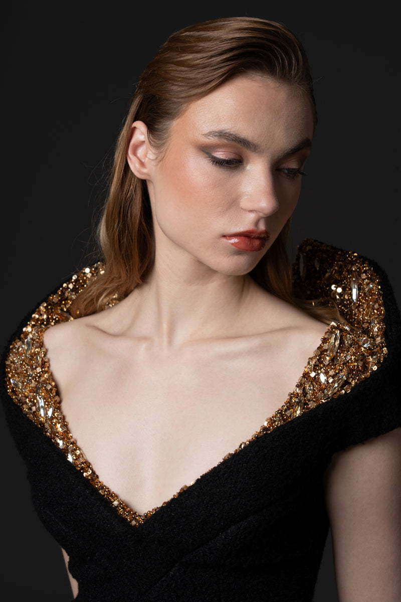 A bouclé gown with a V neckline and a structured beaded collar