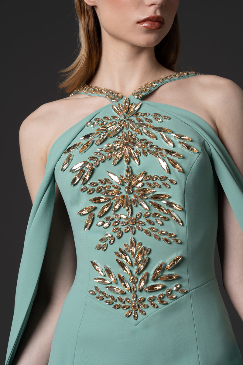 A crêpe fitted gown featuring long sweeping sleeves and beaded corset  with crystals and stones